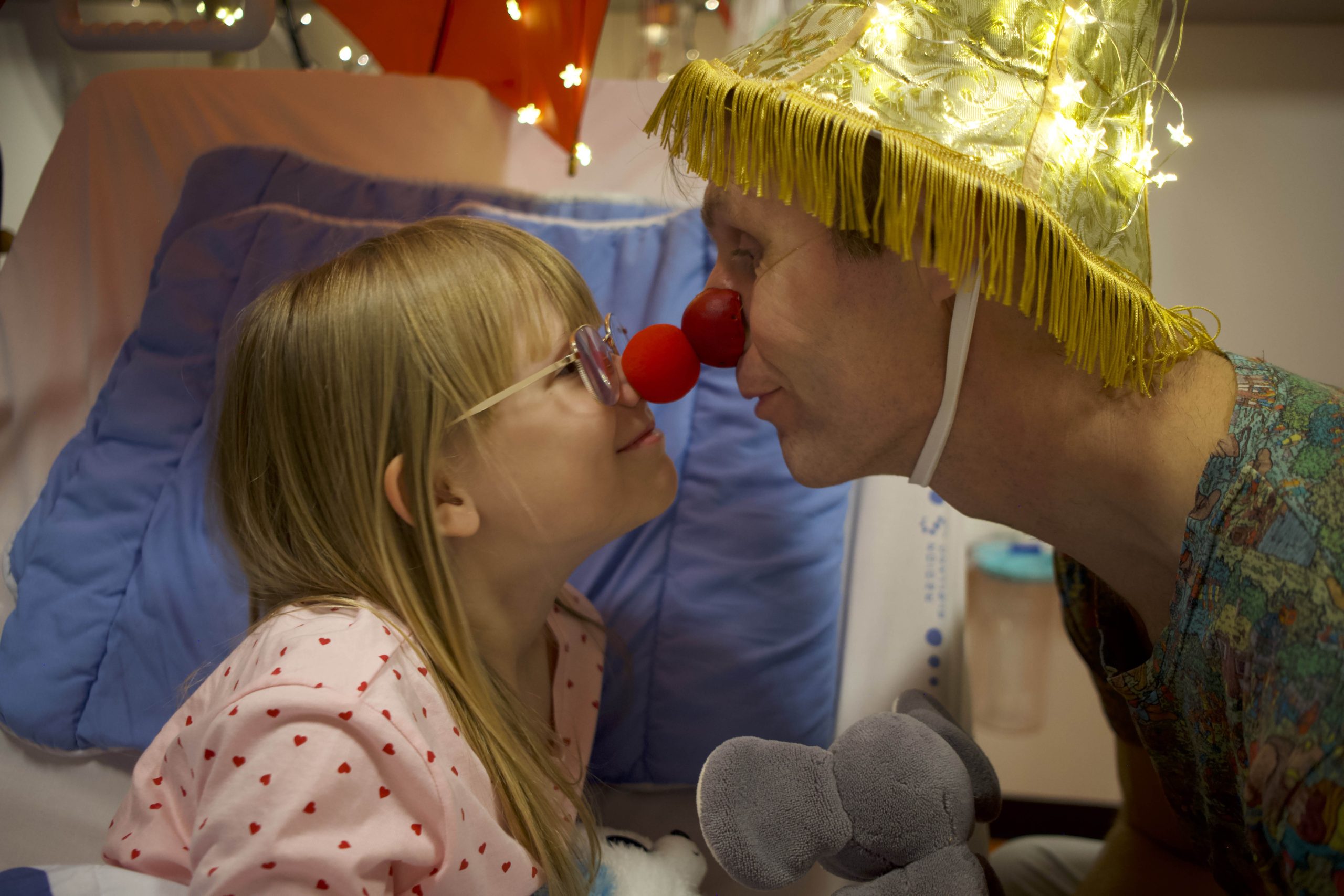 Mynthe og hospitalsklovnen Otto sidder i en hospitalsseng, hvor de kigger på hinanden og presser næserne mod hinanden.