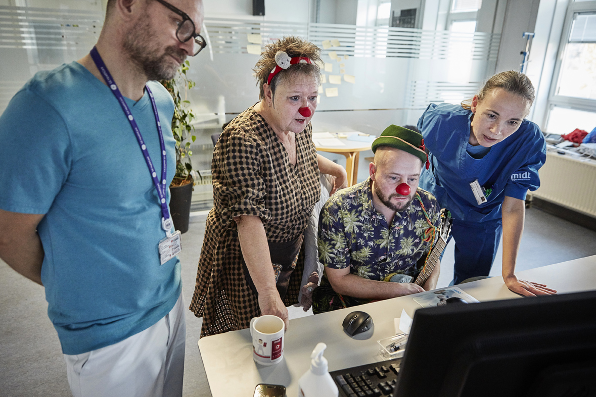 To radiografer og to hospitalsklovne kigger på en computerskærm, som viser MR-scannings-resultater