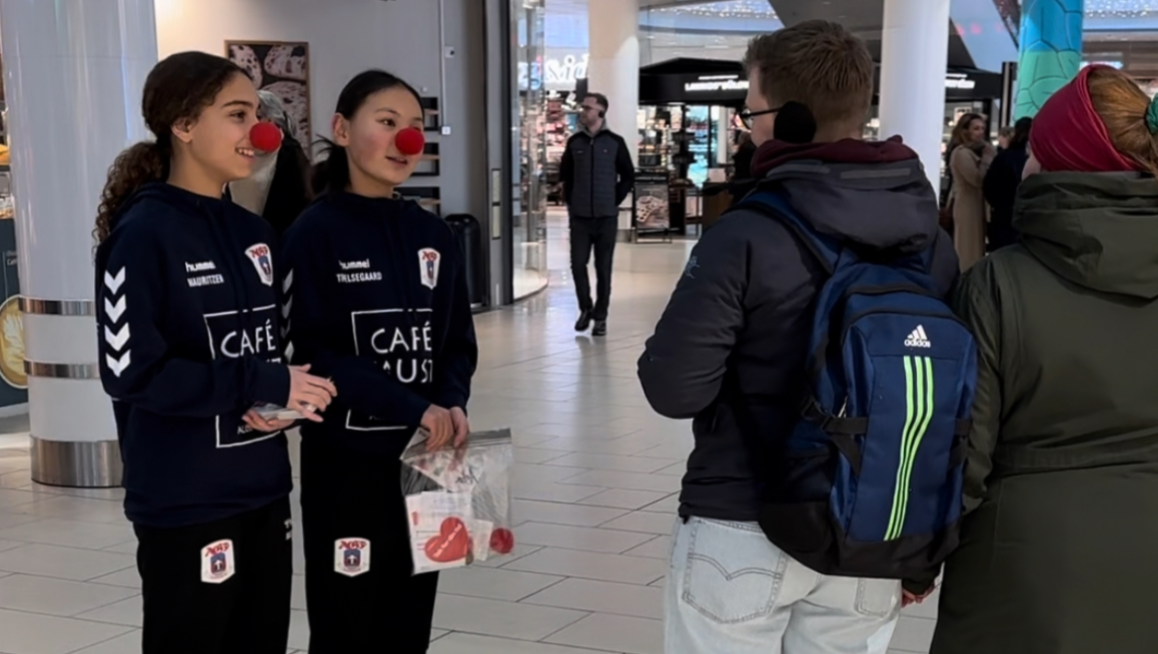 To piger fra basketball klubben HBBF sælger Klovnenes Julelotteri.