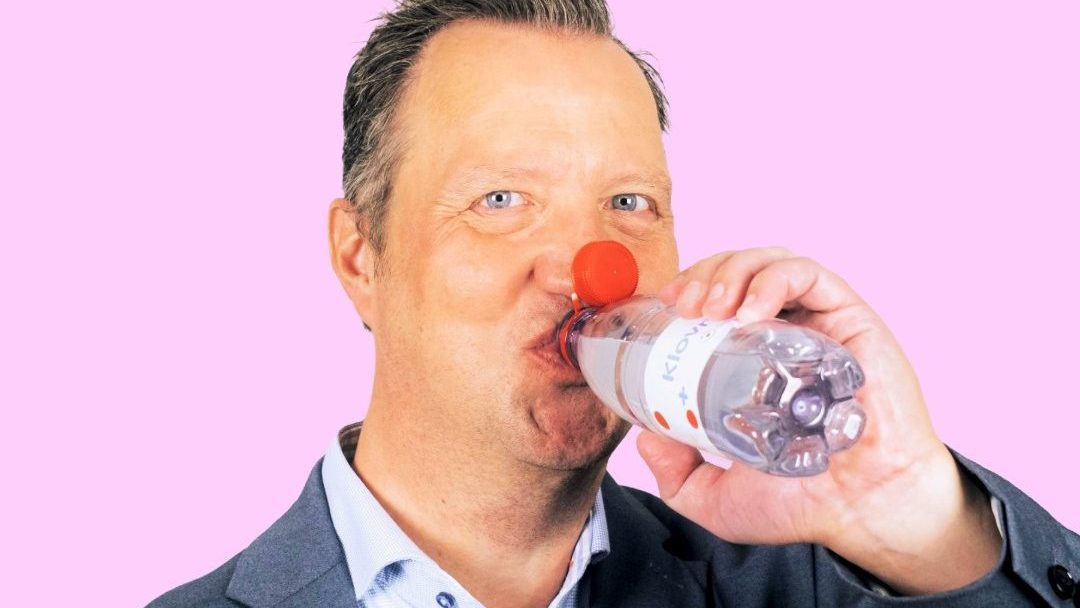 Billede af en mand, Niels Henrik, der drikker af en vandflaske. Flaskens skruelåg er rødt op vipper op i ansigtet, så det kommer til at ligne den røde klovnenæse.