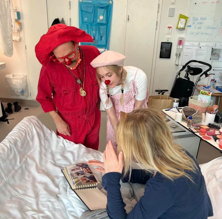 Silja kigger i en bog sammen med hospitalsklovnene Ziggi og Sne