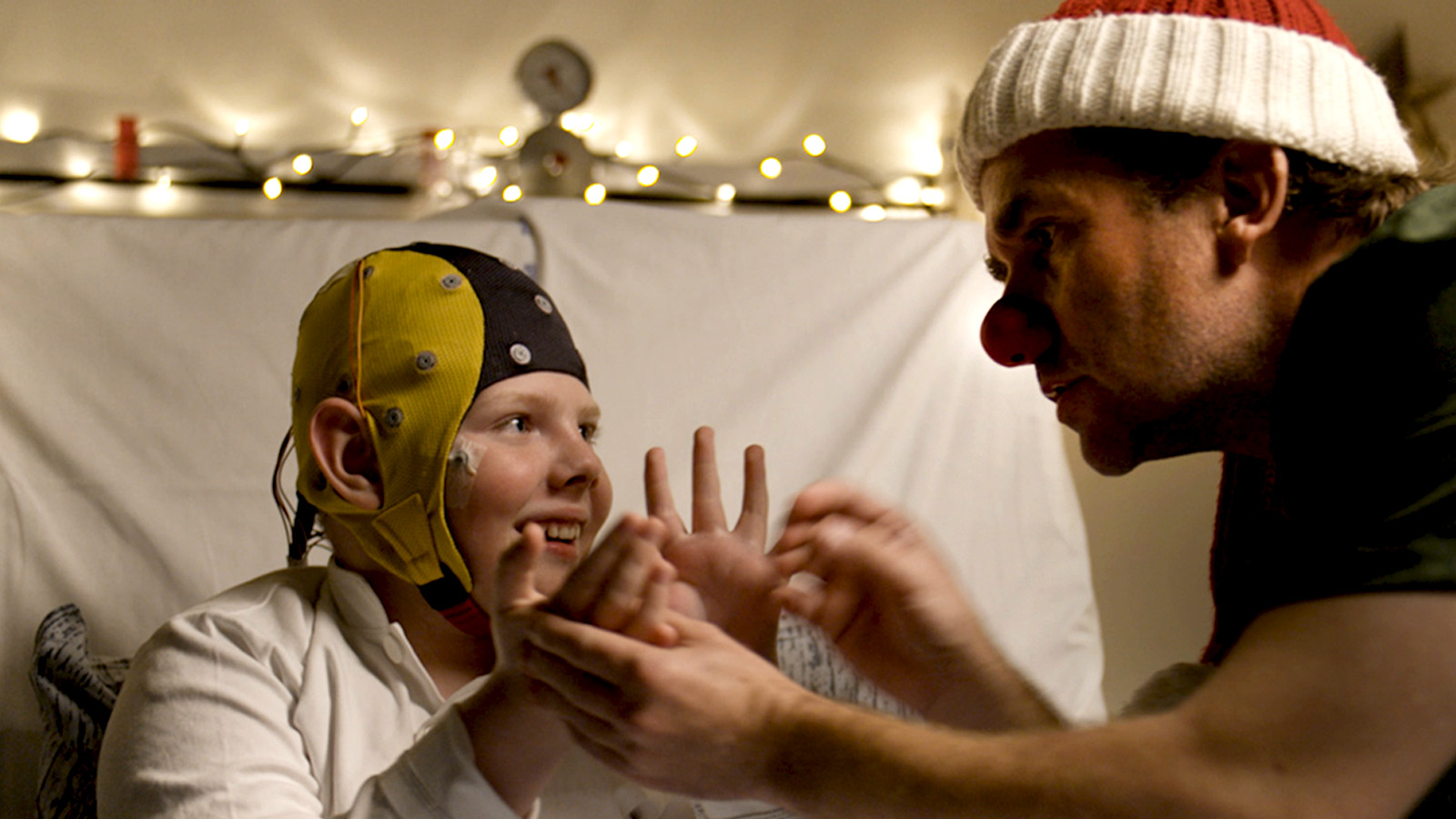 Kalle og hospitalsklovnen Makaroni sidder ved siden af hinanden på en hospitalsstue