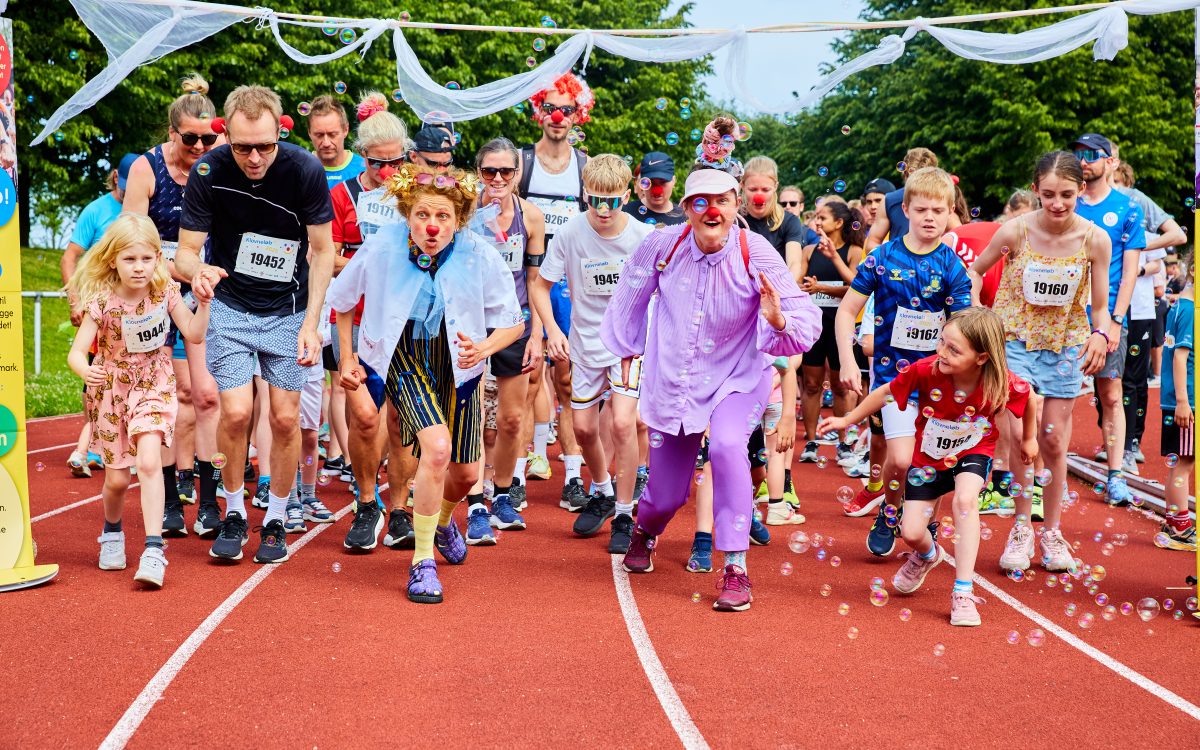 En masse klovneløbere og de hospitalsklovne løber fra målstregen til et klovneløb.